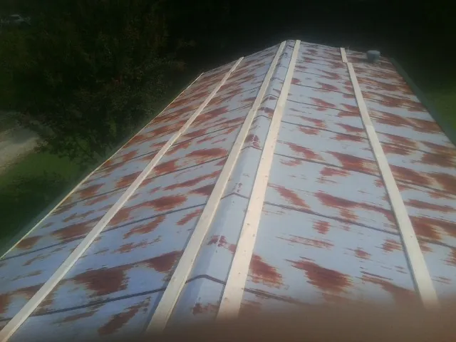 Rusted metal roof panels with new wood purlins before replacement — Storm Damage Roof Repair in Reydon by Roofing Brothers